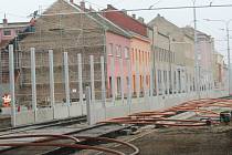 Dělníci staví kolem nové tramvajové tratě na Plotní vysoké a betonové protihlukové stěny.