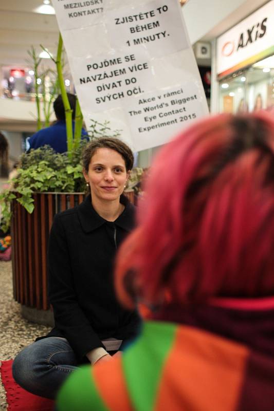 Stojí nebo sedí na lavičkách a dívají se jednu minutu navzájem do očí. Kolem nich jsou rozmístěné cedule a stojany s nápisy. Podobné skupiny lidí mohli ve čtvrtek potkat kolemjdoucí v Brně v obchodním centru Omega nebo v podchodu u hlavního nádraží.