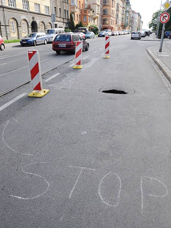 Před budovou Střední zdravotnické školy v Merhautově ulici zeje místo vozovky velká díra.