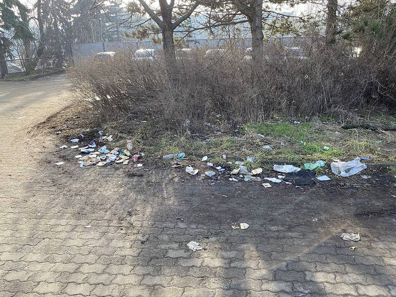 Na parkovišti nad zastávkou Zimní stadion vedle ulice Drobného se povalují odpadky.