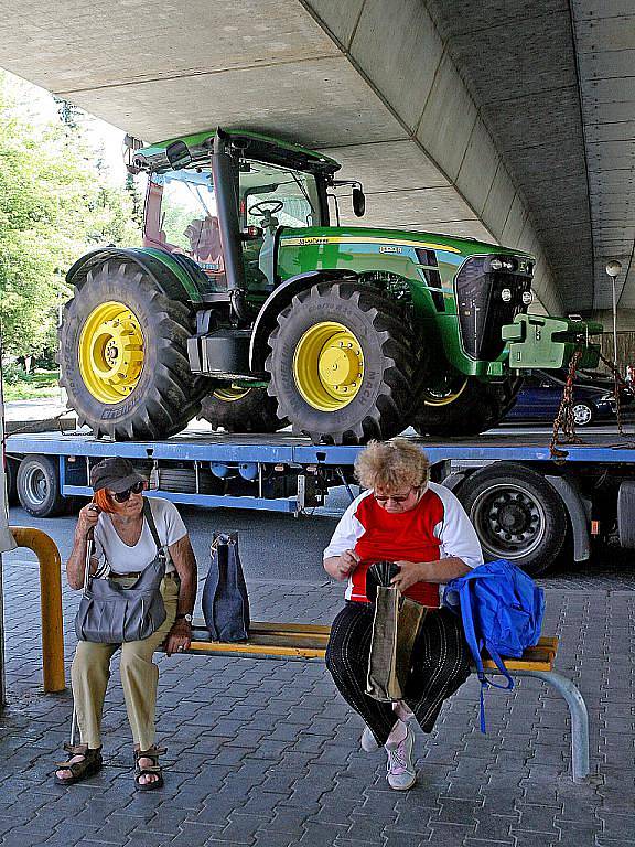 Řidič nákladního auta, které převáželo nový traktor, neodhadl výšku svého nákladu a v podjezdu se zaklínil.