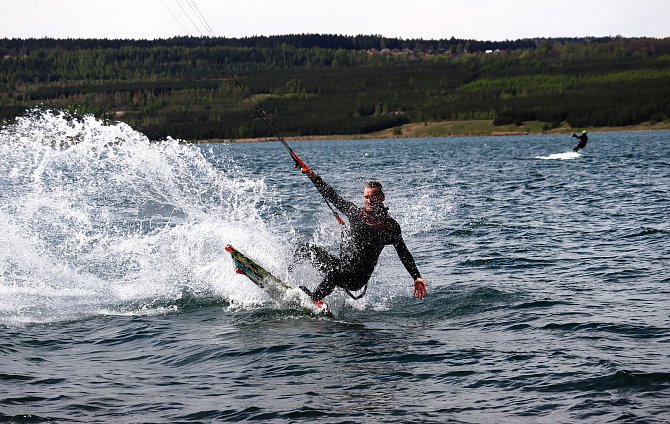 Vodní jezdci tažení drakem ve větru skákali nad vlny jezera Medard