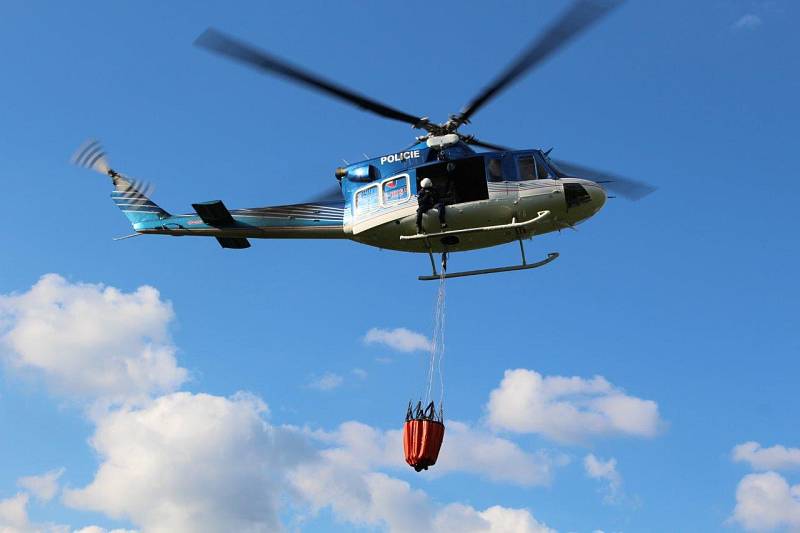 V Rotava hoří les. Zasahuje vrtulník, který hasí ze vzduchu kvůli nepřístupnosti terénu.