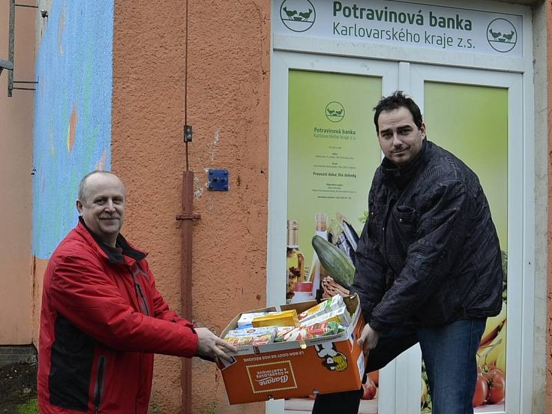 Ředitel potravinové banky Milan Hloušek (vpravo) vydává ze skladu potraviny Liboru Račkovi, vedoucímu Pečovatelské služby v Kynšperku nad Ohří