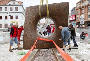 BRÁNA ČASU. Sochař Albert Králiček (na snímku v modrém) instaloval spolu s uměleckými slévači, bratry Horákovými, na Křižíkovo náměstí v Táboře bronzovou plastiku s názvem Brána času a Cesta. Jsou na ní otisky nohou a rukou obyvatel, v noci bude svítit.