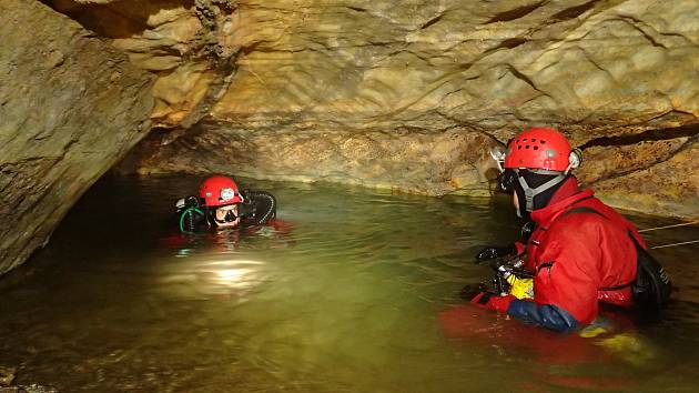Potápěči při přípravě k ponoru v zatopené části jeskyně.