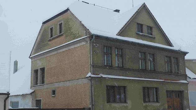 Zimní fotografie domu na náměstí v Malšicích. V přízemí býval obchod.