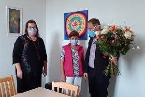 Ředitel diecézní Charity Jiří Kohout společně s vedoucí služeb Střediska DCHCB Petrou Brychtovou předali kytici s 15 růžemi pracovnici Janě Komardinové (uprostřed).