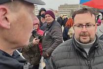 Marek Adam na dubnové demonstraci na Letné vysvětluje své názory policistům. Rusko podle něj na Ukrajině osvobozuje oběti genocidy.