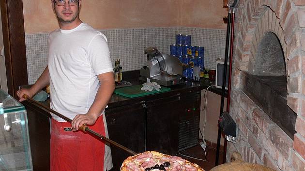 MÁTE CHUŤ? Příprava italského pokrmu v kuchyni táborské pizzerie. Také pizza musí splňovat hmotnostní předpoklady.