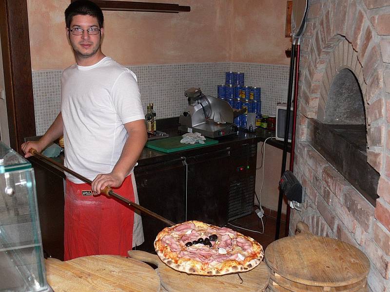 MÁTE CHUŤ? Příprava italského pokrmu v kuchyni táborské pizzerie. Také pizza musí splňovat hmotnostní předpoklady.