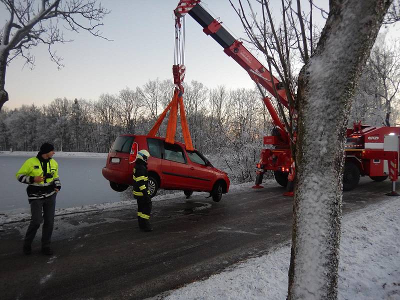 Hasiči vytahují automobil, který skončil v rybníku v Jistebnici.