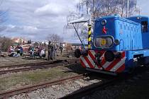 Malá posunovací lokomotiva a účastníci jarního pochodu podél trati při opékání buřtů na bezdružickém nádraží.