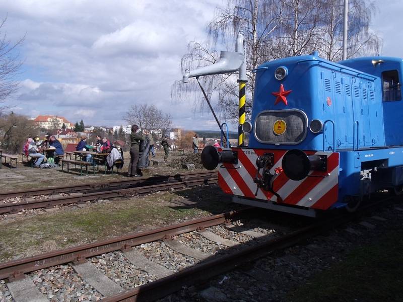 Malá posunovací lokomotiva a účastníci jarního pochodu podél trati při opékání buřtů na bezdružickém nádraží.