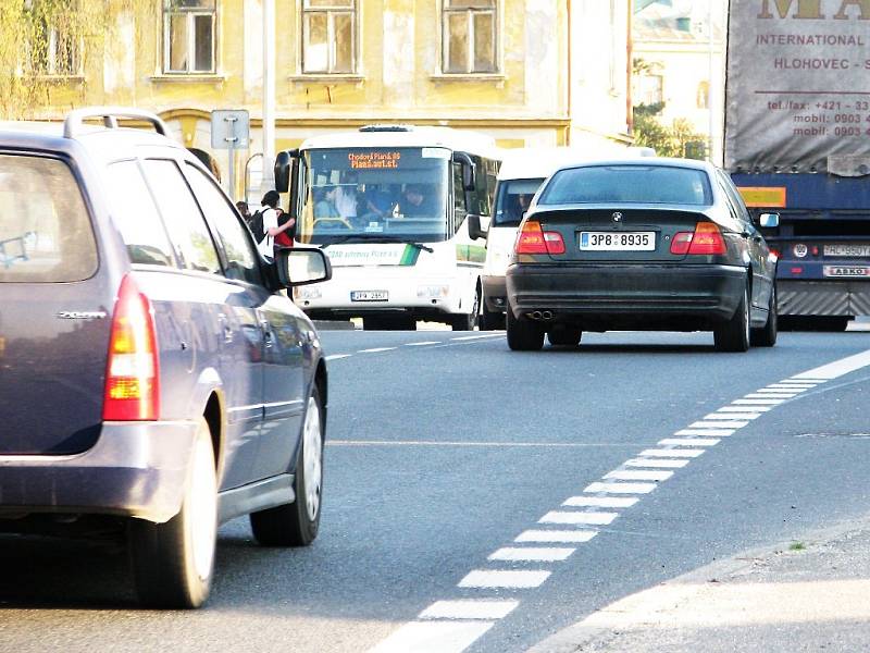 RANNÍ ŠPIČKA V CHODOVÉ PLANÉ (na snímku u autobusových zastávek).  Souvislá řada jedoucích aut, intenzivní provoz kamionů a téměř nemožnost přejít v době dopravní špičky třídu Pohraniční stráže, taková je denně situace v Chodové Plané.