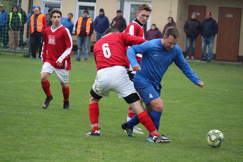 Studánecký záložník Jakub Šuranský (v modrém) se úspěšně prodírá dvojblokem soupeřovo hráčů.