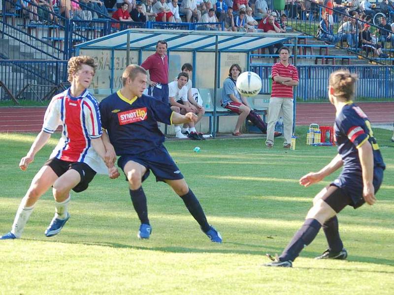 Fotbalisté FK Tachov remizovali na městském stadionu s favorizovanou Jiskrou Domažlice 2:2. Na snímku zastavuje mladíčka v dresu domácího celku Tomáše Habarta (vlevo) dvojice domažlických obránců.