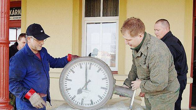 Jiří Bízek a Marek Plochý (zleva) ukazují historické hodiny, které budou po opravě sloužit na bezdružickém nádraží