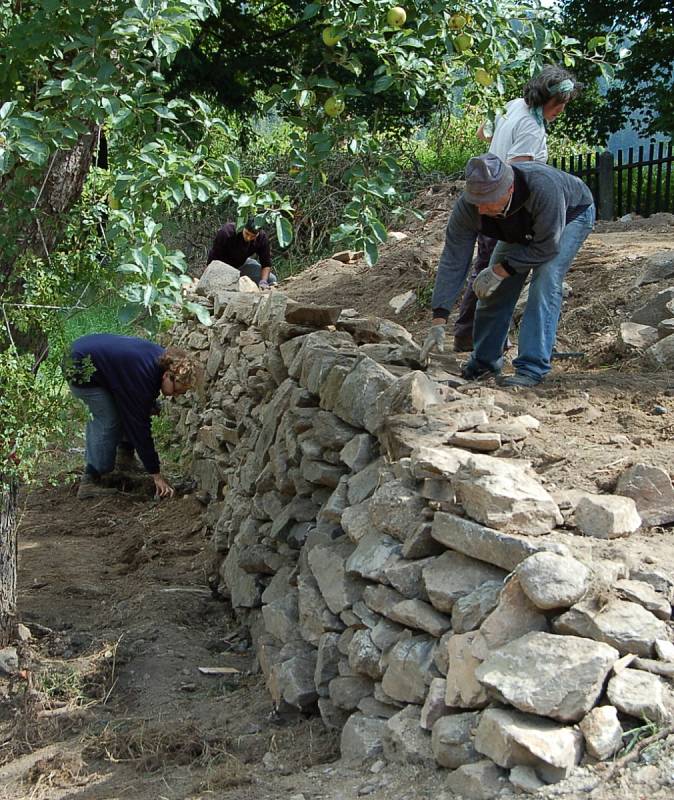 Dobrovolníci z několika zemí světa pomáhají obnovovat stezky v oblasti Michalových Hor i plot bývalé fary, také odkryli cestu ke kostelu.