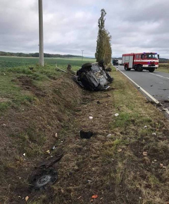 Policejní auto skončilo po srážce s traktorem v příkopu.