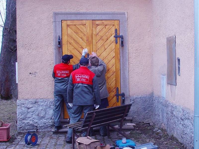 Instalace nových vchodových dveří v kostele Petra a Pavla v Milířích. Kostel čeká ještě řada dalších oprav. 