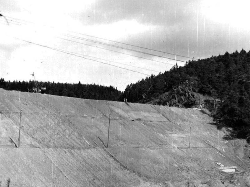 Čerstvě nasypaná a urovnaná hráz je v roce 1963 téměř kompletně hotova, voda během roku 1964 nenávratně zatopí údolí řeky od úrovně pod Stříbrem po ves Hracholusky. 