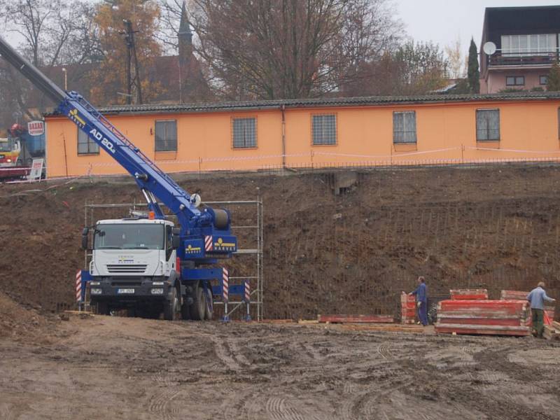 Jeřáb staví šalovací desky. Místo by se mělo proměnit v supermarket a dům služeb. 