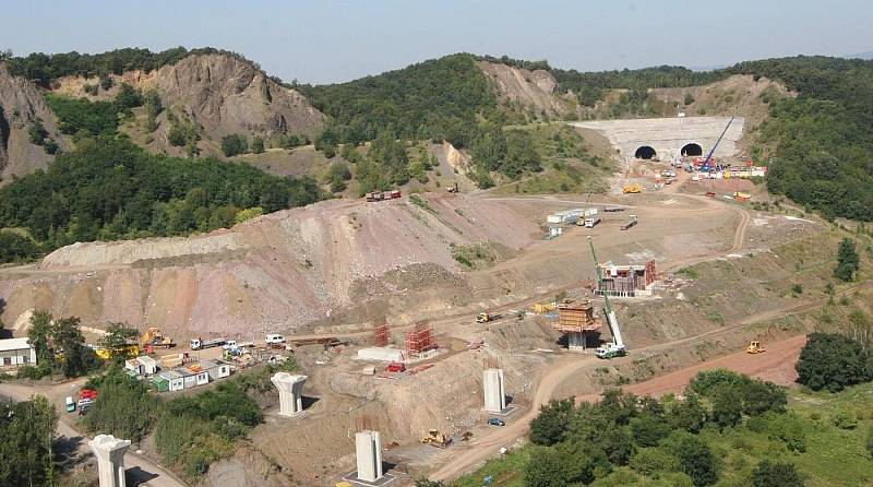 Letecký pohled na výstavbu dálnice D8 přes České středohoří. Pohled je na výstavbu dálnice od obloukového mostu v Opárně až po tunel Prackovice.