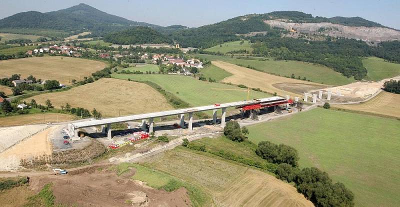 Letecký pohled na výstavbu dálnice D8 přes České středohoří. Pohled je na výstavbu dálnice od obloukového mostu v Opárně až po tunel Prackovice.