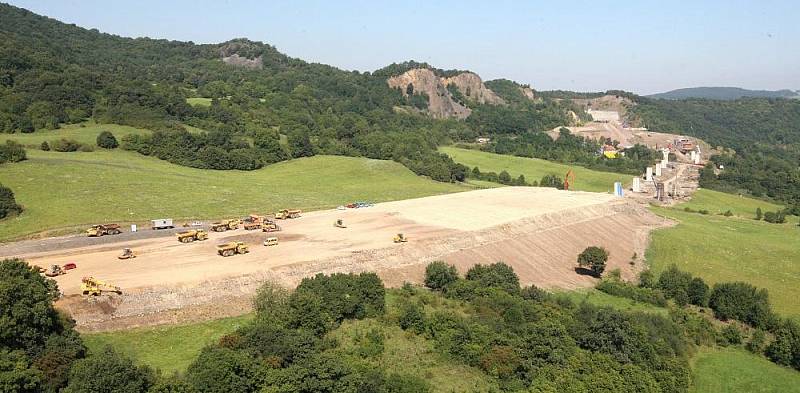 Letecký pohled na výstavbu dálnice D8 přes České středohoří. Pohled je na výstavbu dálnice od obloukového mostu v Opárně až po tunel Prackovice.