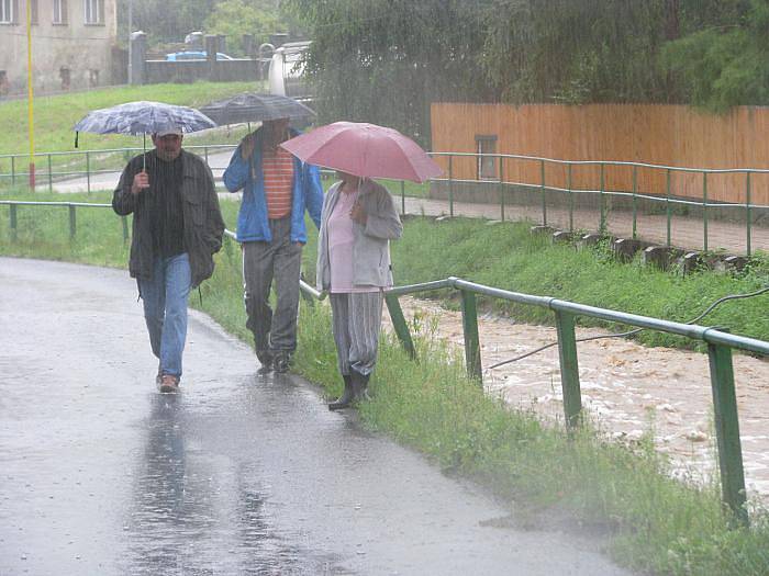 Voda v Povrlech zatopila fotbalové hřiště, koupaliště, chatovou oblast a voda se valí dále po silnici.