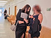 Ženu (zcela vpravo s rozrastrovanou tváří) obžalovali kvůli smrti dítěte v Ústí při neasistovaném porodu, k soudu přišel i otec dítěte (vzadu v asistenci policie).