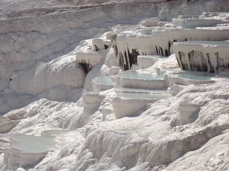 Jedna z největších turistických atrakcí v Turecku je Pamukkale. Na obrázku je svah pokrytý sněhově bílým travertinem, který vzhledem připomíná bavlněný hrad. Autorkou snímku je Taťána Turková, Most.