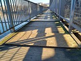 Lávka pod železničním mostem v Ústí nad Labem. Část je opravená, část ovšem stále trpí četnými dírami, které město nechalo překrýt dřevotřískovými deskami.