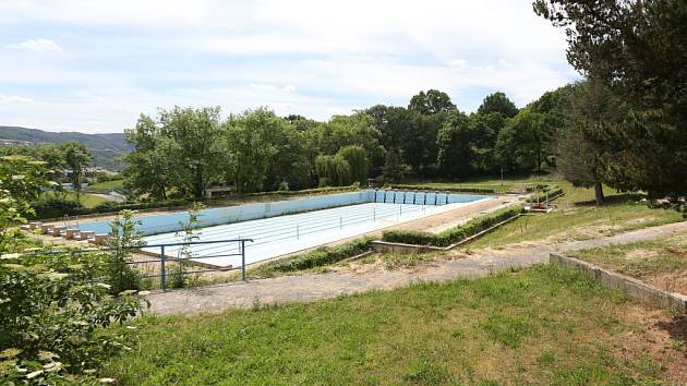 Venkovní bazén na Klíši je vypuštěný a uzavřený. Postupně zarůstá trávou a plevelem.