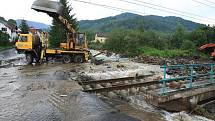 Obec Těchlovice: Obrovské kameny, písek a hlínu nyní odklízí těžká technika, ale stále přitékající voda komplikuje čištění tratě.