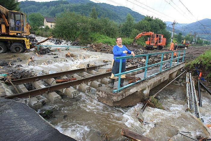 Obec Těchlovice: Obrovské kameny, písek a hlínu nyní odklízí těžká technika, ale stále přitékající voda komplikuje čištění tratě.