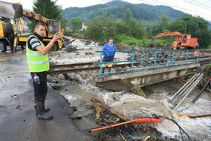 Obec Těchlovice: Obrovské kameny, písek a hlínu nyní odklízí těžká technika, ale stále přitékající voda komplikuje čištění tratě.