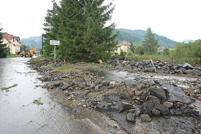 Obec Těchlovice: Obrovské kameny, písek a hlínu nyní odklízí těžká technika, ale stále přitékající voda komplikuje čištění tratě.