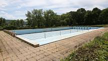 Venkovní bazén na Klíši je vypuštěný a uzavřený. Postupně zarůstá trávou a plevelem.