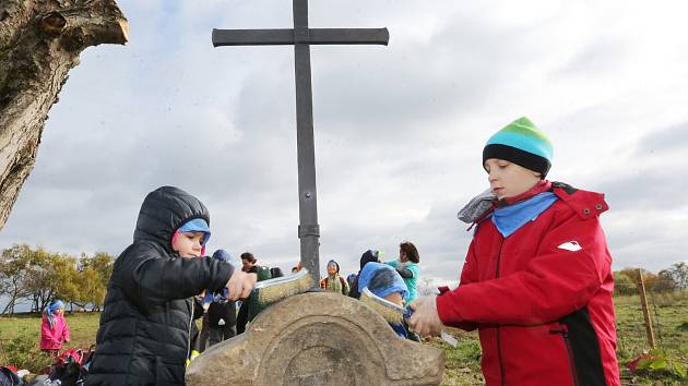 Děti z Petrovické základní školy pomohly mistrovi kovářskému vztyčit nový kříž na pastvinách nad obcí.