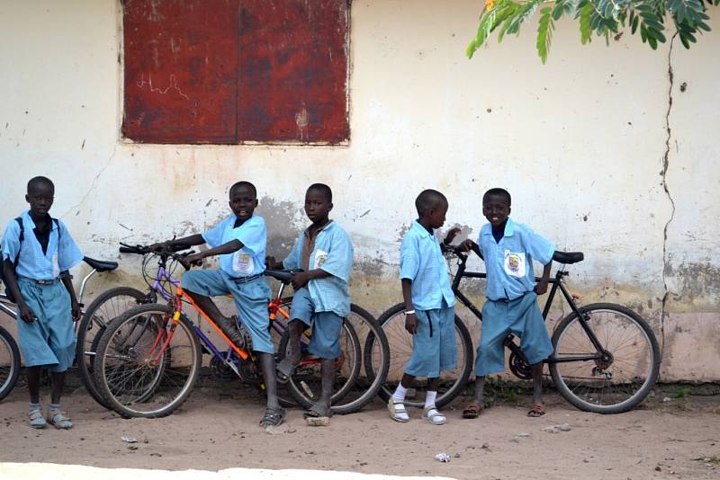 Děti s koly u školy.