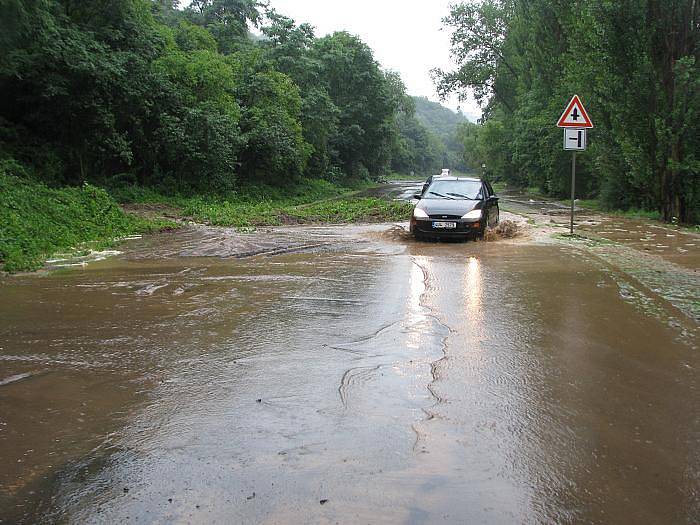 V Brné se sesunula opěrná zeď a zasypala celou silnici. Proud vody se přes ní stále valí dál.