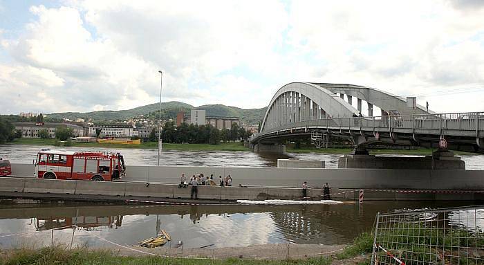 Voda zatopila Přístavní ulici v Ústí nad Labem. Na místě zasahují profesionální i dobrovolní hasiči, kteří pytlují vaky, kterými se snaží utěsnit komunikaci. Vodu z ní poté odčerpají.