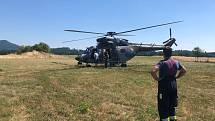 Oheň hasí vojenská helikoptéra a dvě letadla. Vodu jim doplňují uprostřed nesnesitelného vedra dobrovolní hasiči, například telnická jednotka, ve které dobrovolně slouží i zdejší starosta Jan Doubrava.