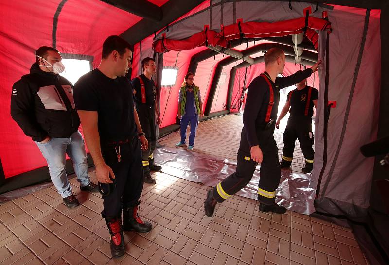 V Ústí nad Labem v Masarykové nemocnici dnes stavěli hasiči třídící stan (červený) a odběrové místo (modrý stan).