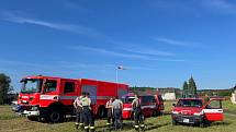 Oheň hasí vojenská helikoptéra a dvě letadla. Vodu jim doplňují uprostřed nesnesitelného vedra dobrovolní hasiči, například telnická jednotka, ve které dobrovolně slouží i zdejší starosta Jan Doubrava.