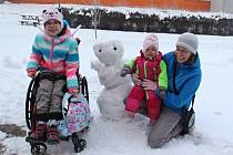 Sestry Saša a Máša z Dobětic se svou maminkou využily sněhové nadílky u školy starší z dívek a pustily se nadšeně do stavby sněhuláka.