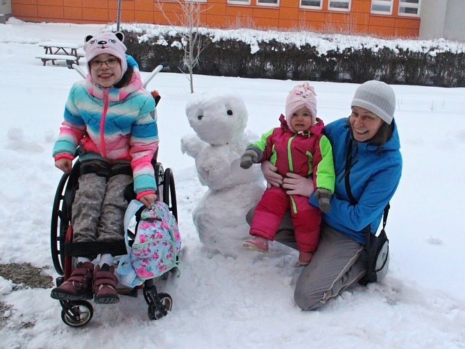 Sestry Saša a Máša z Dobětic se svou maminkou využily sněhové nadílky u školy starší z dívek a pustily se nadšeně do stavby sněhuláka.