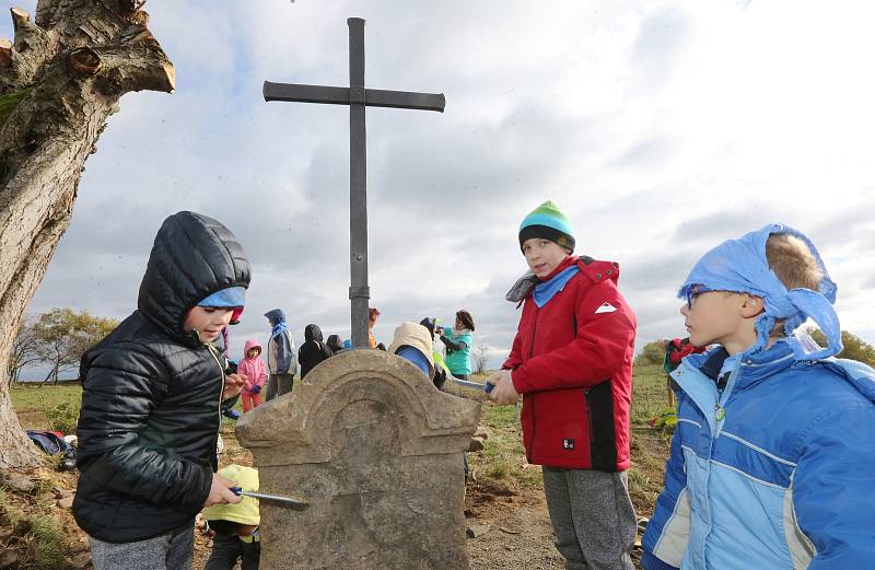 Děti z Petrovické základní školy pomohly mistrovi kovářskému vztyčit nový kříž na pastvinách nad obcí.